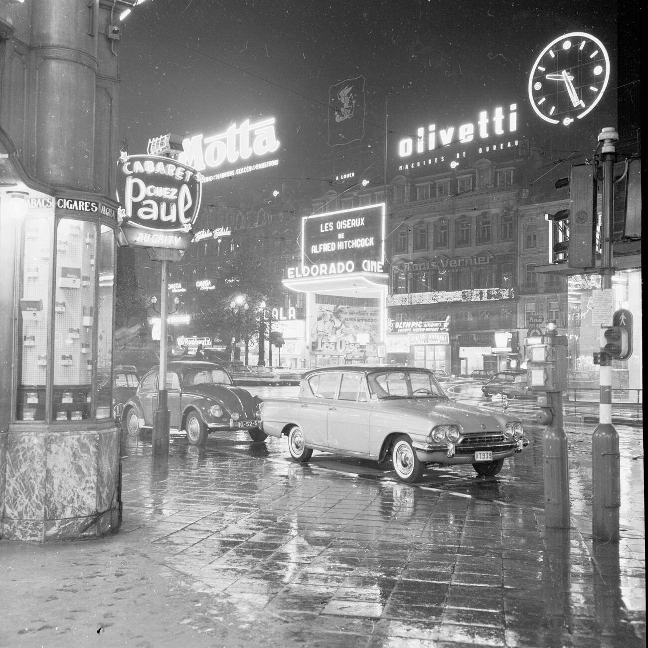 A wet street, evening time Brussels, Belgium, lit up by advertising hoardings and signs, 1950s