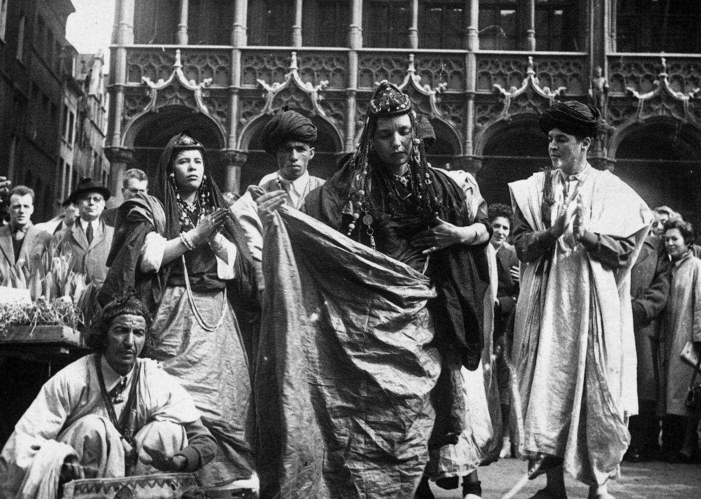 A group of dancers of the Hommes Bleus (Blue People) tribe of Morocco performing a national dance in traditional garb in the Grand Place at Brussels, 1950