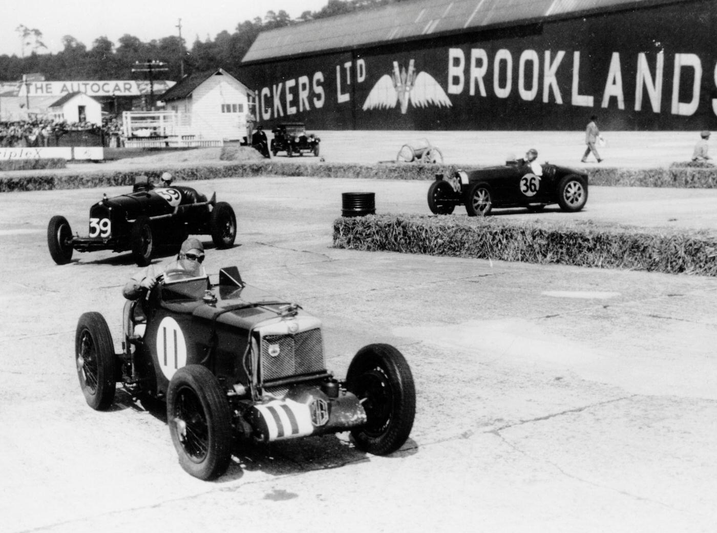 Action from the British Empire Trophy Race, Brooklands, Surrey, 1935. An MG leads an Alfa Romeo and a Bugatti round a hairpin bend.