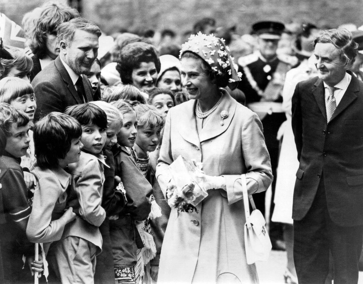 Queen Elizabeth II visiting Wales during the silver jubilee tour. Pictured chatting to youngsters at Caerphilly castle, 24th June 1977.