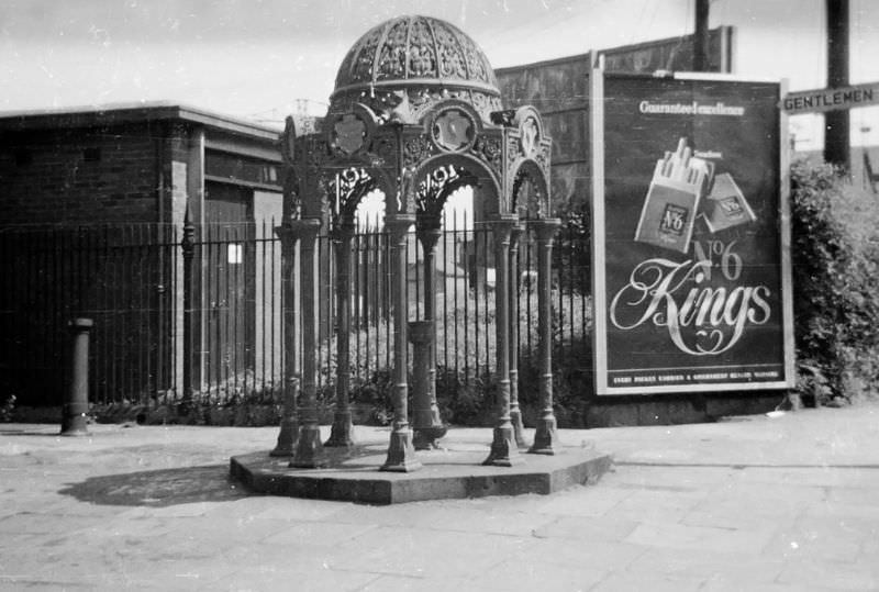 Tiger Bay Fountain. A fountain that once stood at the entrance to the Bute Docks in Cardiff's Butetown. Now relocated, and in Victoria Park, Canton. You don't see adverts for cigarettes like this anymore, Cardiff, February 1971