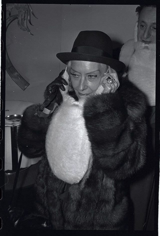 Gloria Swanson wearing a Santa wig while attending a holiday party, 1978.