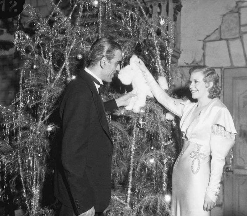 Ginger Rogers chats with actor Boris Karloff next to a Christmas tree at a Hollywood charity gala, 1932.