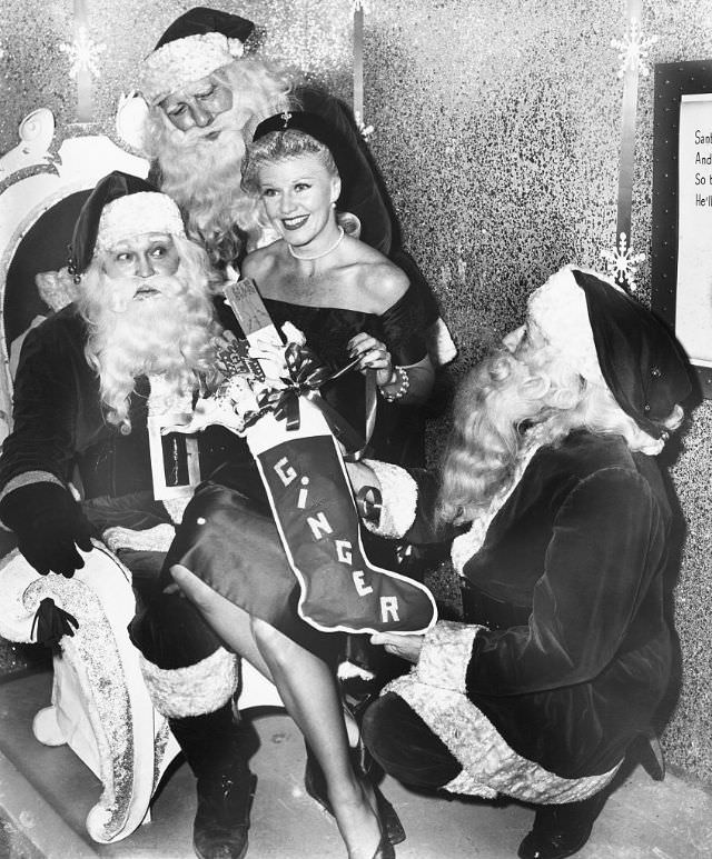 Ginger Rogers surrounded by multiple Santa Clauses, 1950.