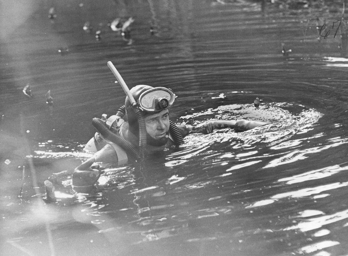 David Mathias, an experienced scuba diver prepares to examine floor of lake in Coal Creek Canyon for hidden weapons, 1967