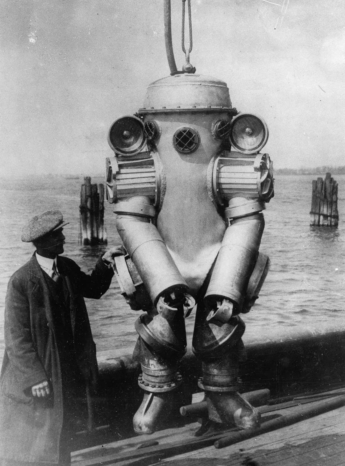 American inventor H.L. Bowdoin with his deep-sea diving suit, featuring shoulder-mounted 1,000-watt lamps and an integrated telephone. 1931.