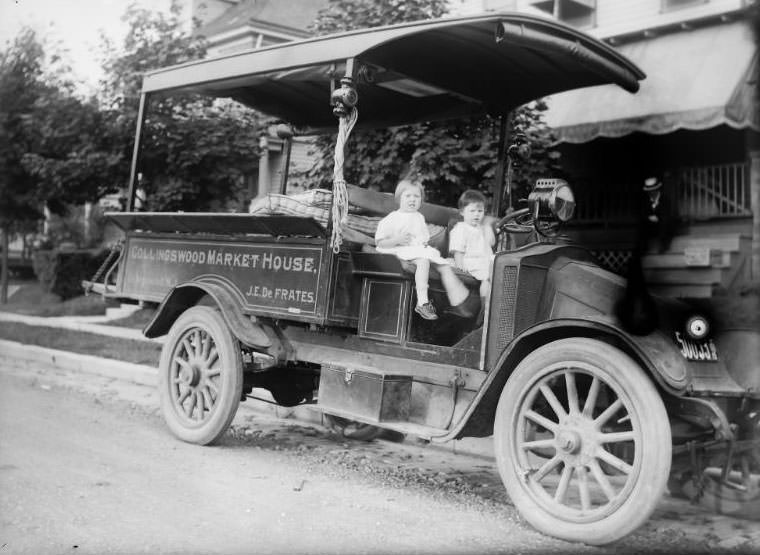 Collingswood Market House Truck owned by J.E. De Frantes. It's hauling mattresses with 2 young children sitting in the truck, 1915