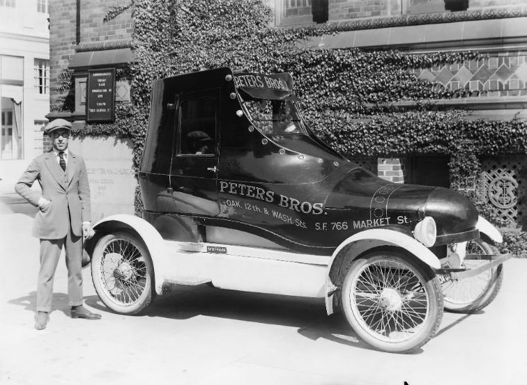 A working Peters Bros. Shoe Repair promotional car in the shape of a shoe. Pictured in front of a Presbyterian Church in San Francisco, California, 1922