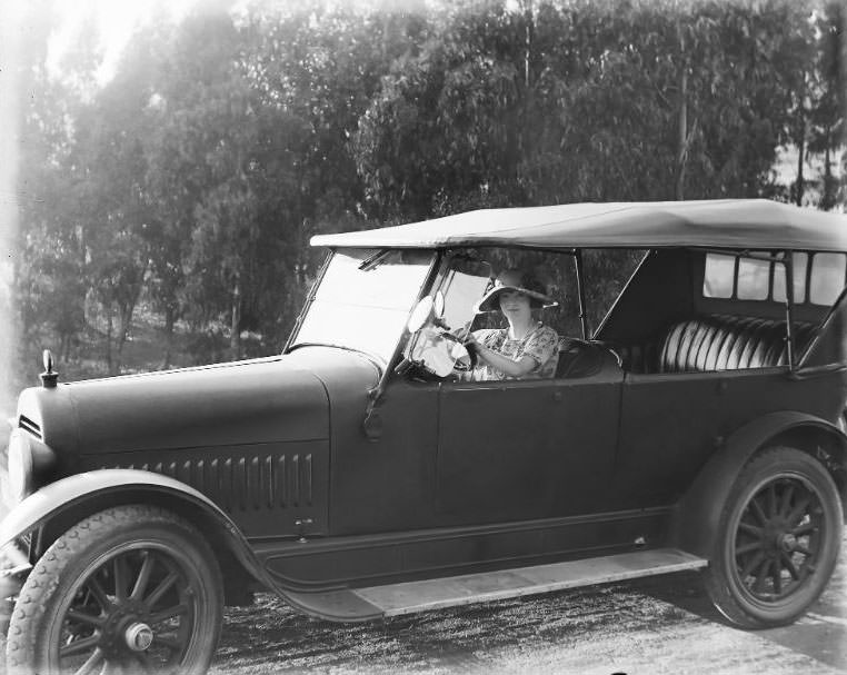 Lady in a touring car along the Southern California coast line, 1920s