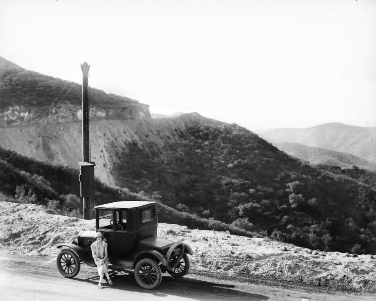 Lady in a touring car along the Southern California coast line, 1920s