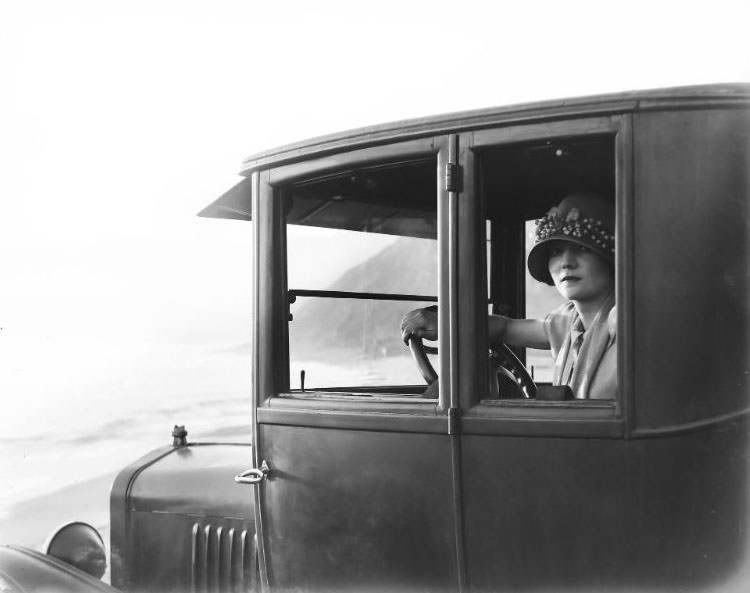 Lady in a touring car along the Southern California coast line, 1920s