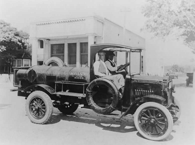A Standard Oil Company Gasoline refueling truck with two men seated inside the cab. San Francisco Bay Area, 1910s