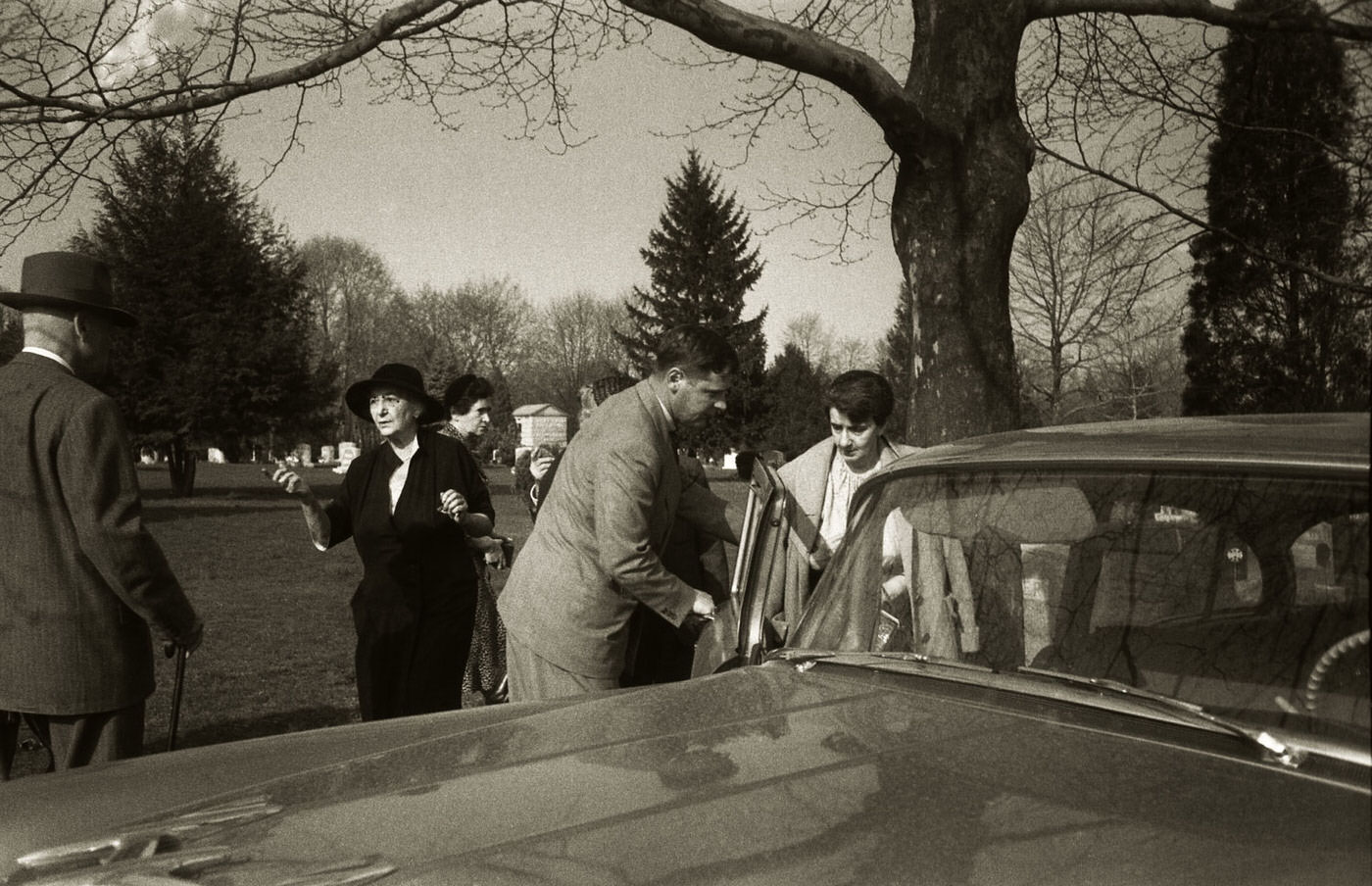 After the cremation service, an unidentified man holds a car door open for Albert Einstein's secretary, Helen Dukas, as she leaves the premises in April 1955.