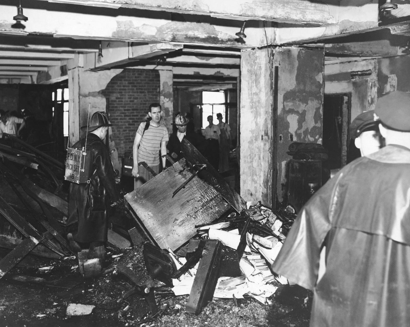 Police and firemen examine a burned out office on the 79th floor of the Empire State Building, 1945