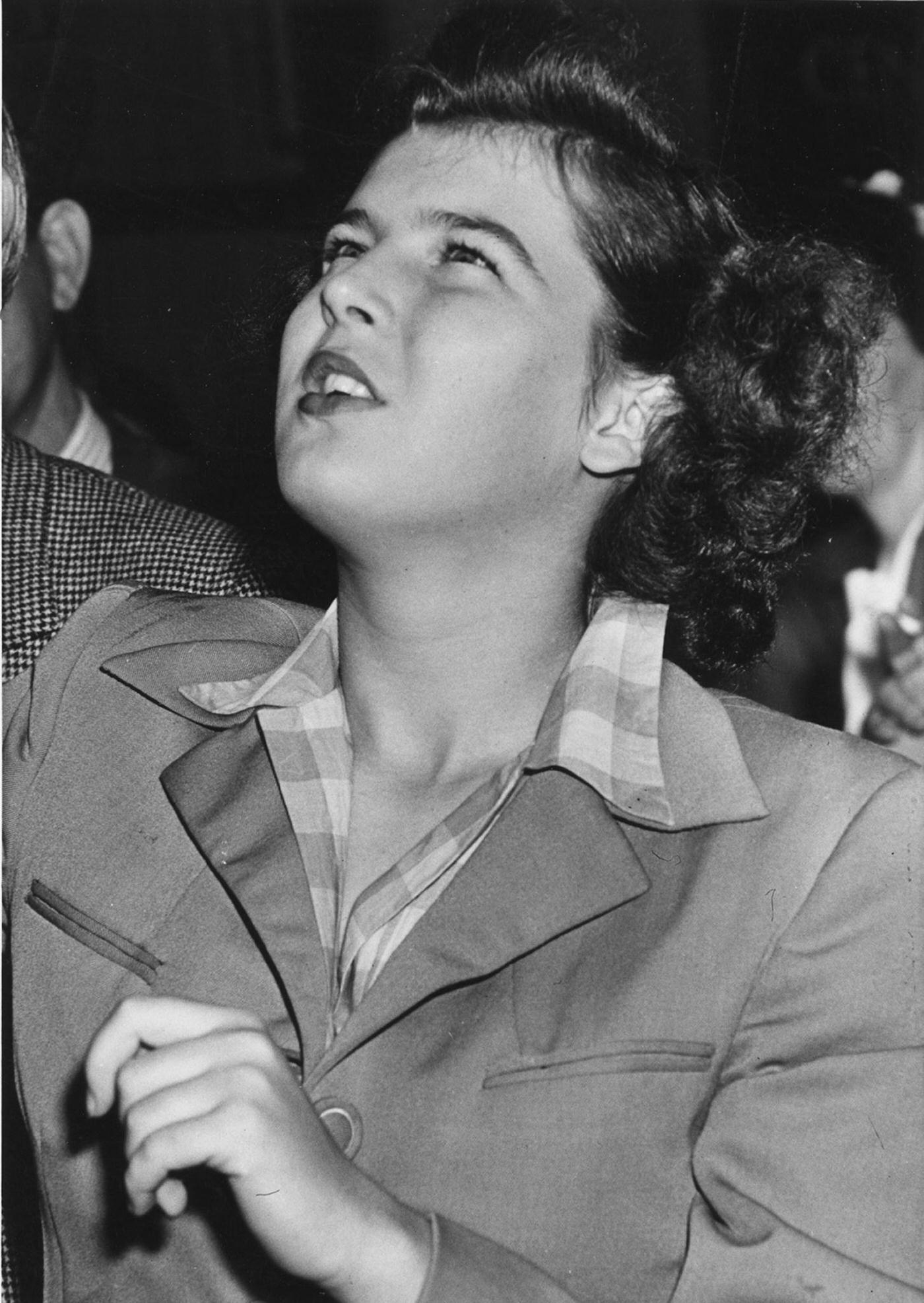 Close-up of a woman as she looks up at the Empire State Building