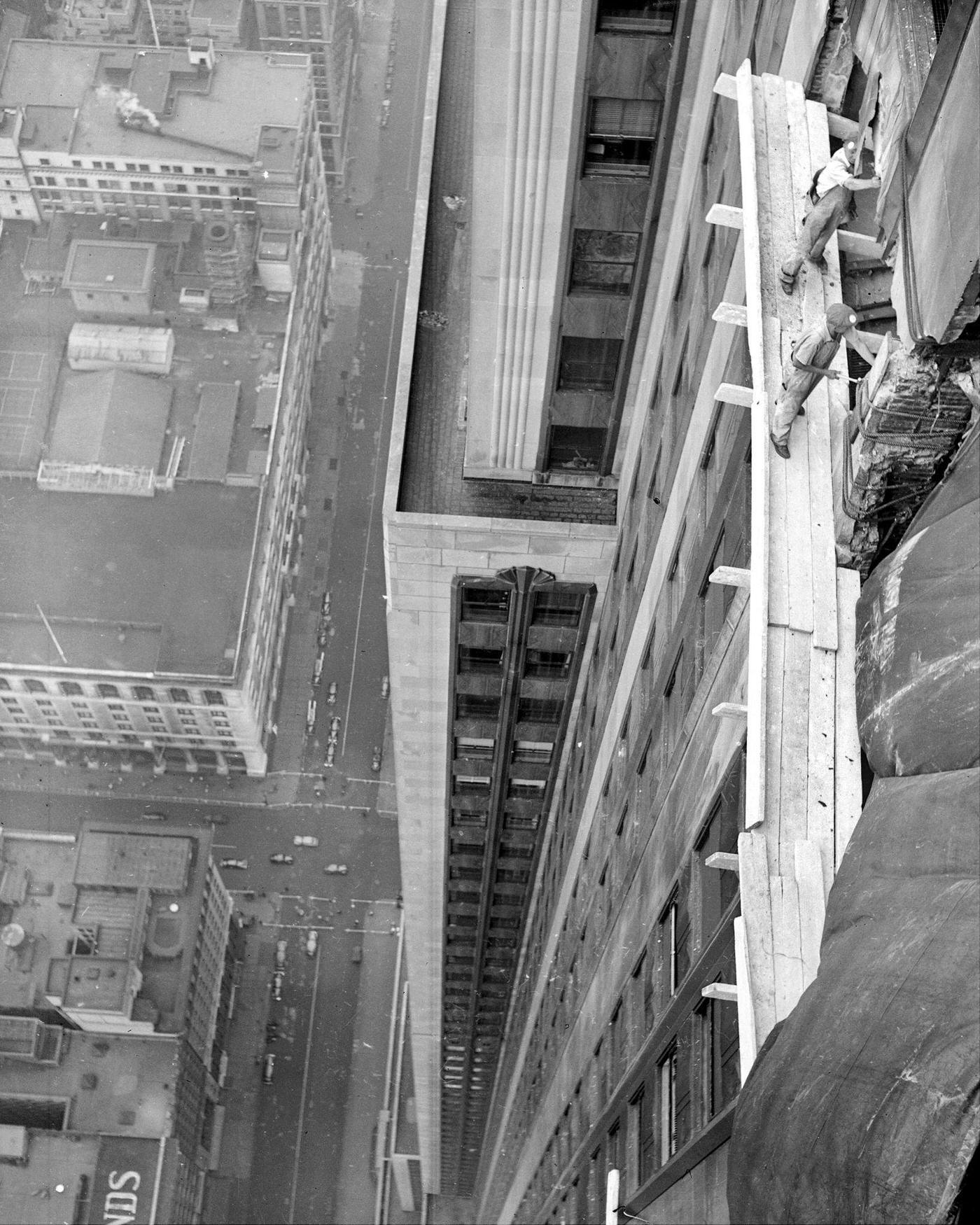 Workmen begin the costly job of repairing the damage done to the worl'd highest building the freak plane crash.