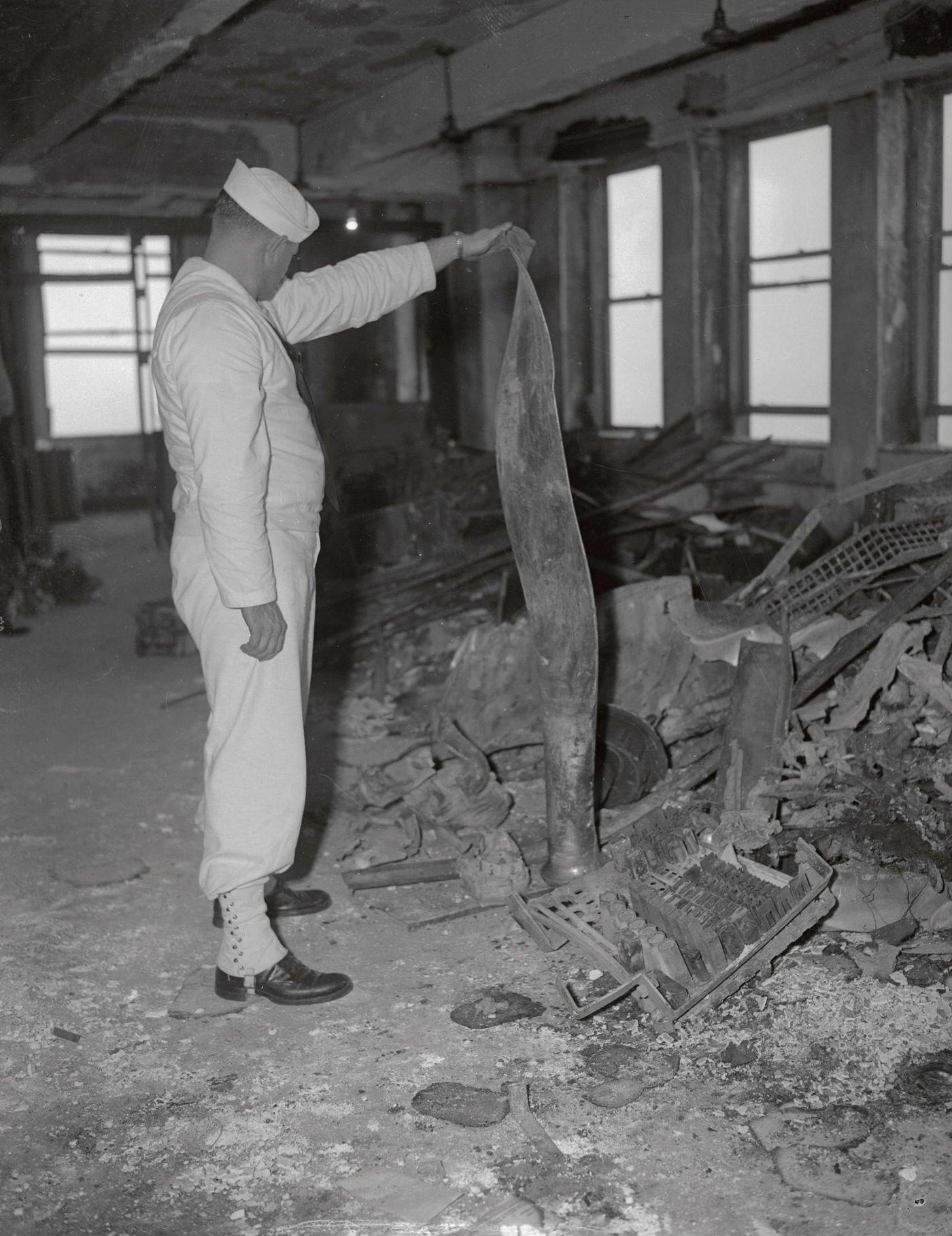 A man holding up debris from the wreckage of a bomber plane which crashed into the empire State Building