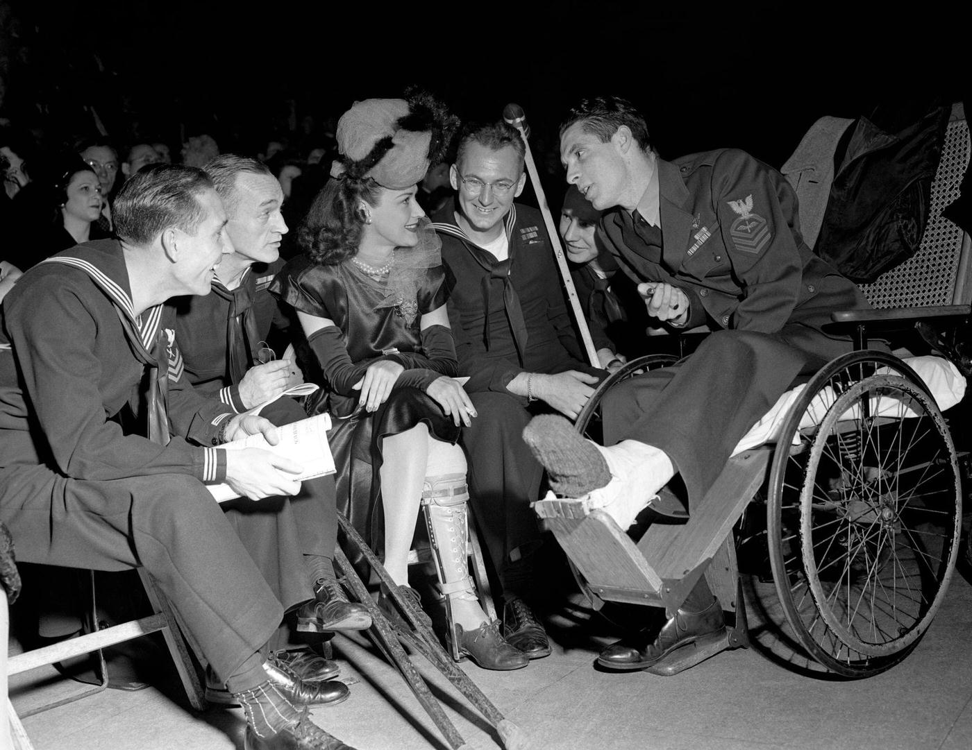 Jane Froman sits and talks to Military personnel during the Newspaper Guild Ball on December 6, 1945 in New York