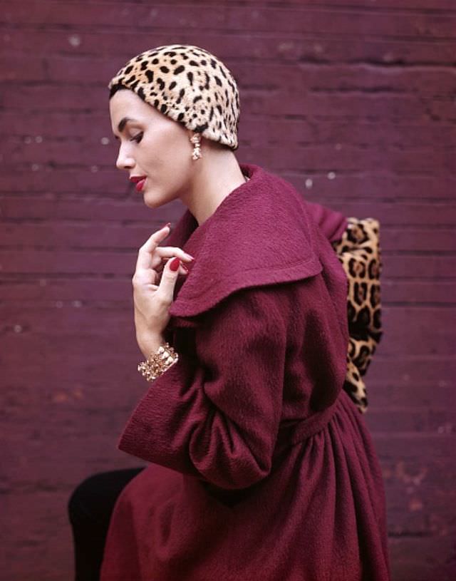 Georgia Hamilton poses in a plum-colored coat designed by Pauline Trigere, jaguar hat skull cap by Mr. John, jaguar muff by Aaron Reiss, jewelry by Schlumberger, 1949