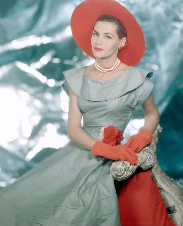 Georgia Hamilton wearing light grey dress with wide round collar, full skirt, and orange hat and gloves, 1949