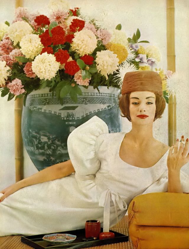 Ruth Neumann Derujinsky in ivory-white silk tussah dress, the sleeves flounce out and the waist is tied with matching ribbon by Larry Aldrich, organdy toque by Walter Florell, photo by Gleb Derujisnky, Harper's Bazaar, April 1959