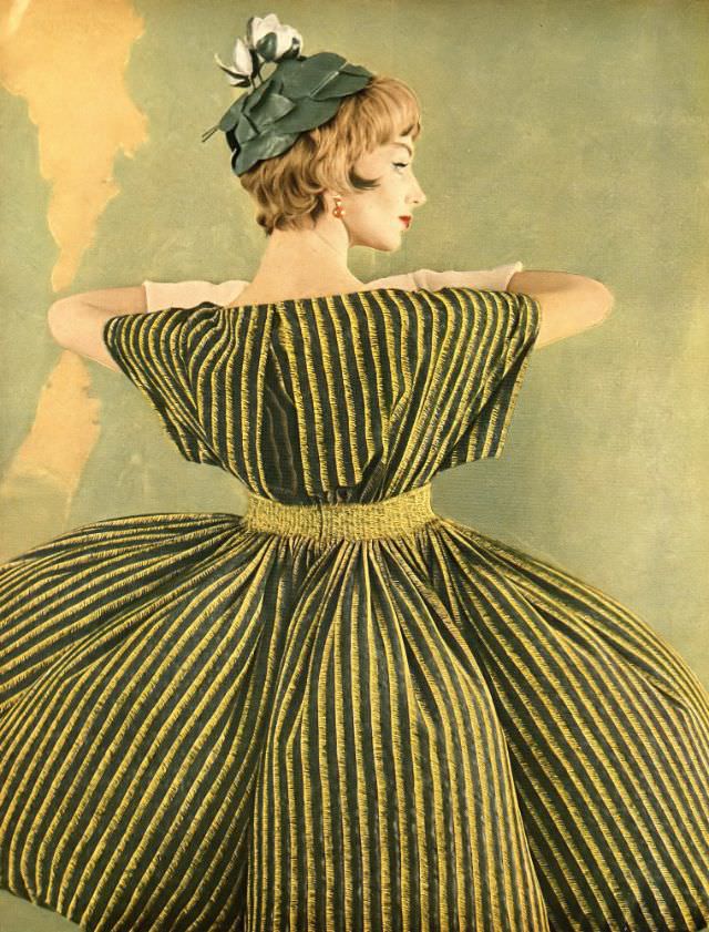 Ruth Neumann Derujinsky in silk crêpe dinner dress of yellow and black stripes on green with wide kimono sleeves by Galanos, leafy green hat by Mr. Arnold, photo by Gleb Derujinsky, Harper's Bazaar, April 1959