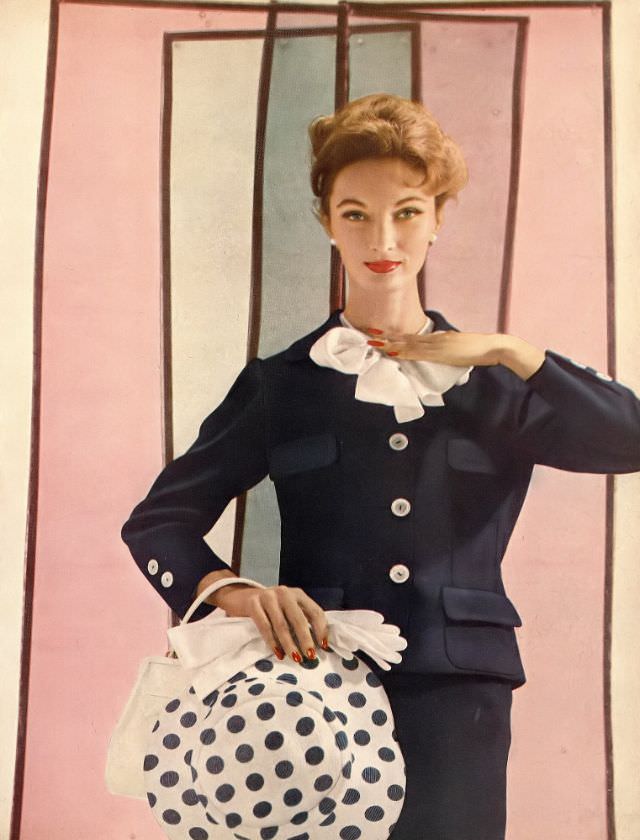 Evelyn Tripp in navy blue suit with white blouse bowed at the collar, photo by Gleb Derujinsky, Harper's Bazaar, February 1957
