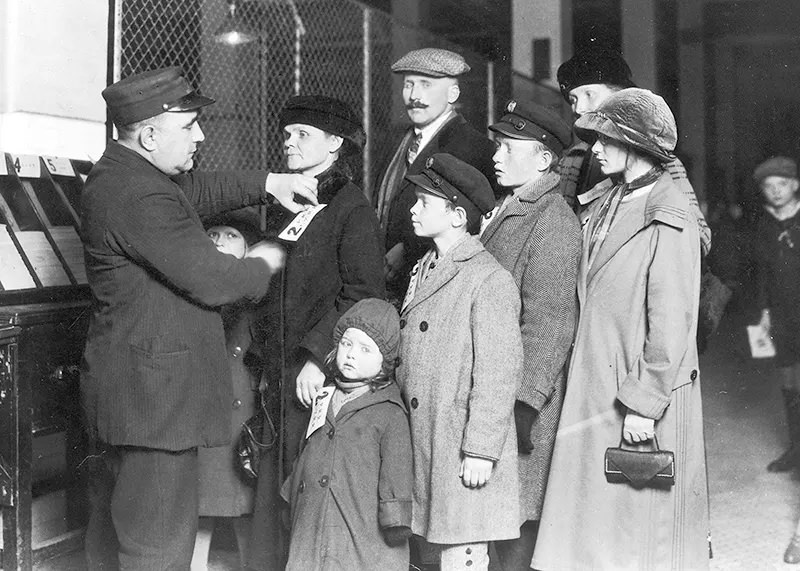 Getting tagged by an official for a railroad trip, 1920s.