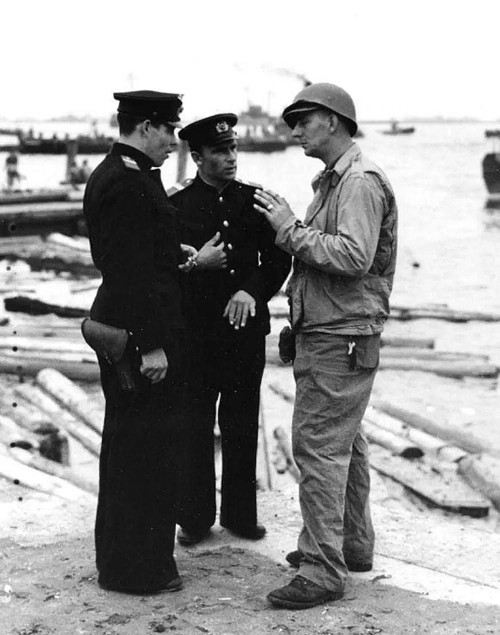 Two Soviet Navy officers talking with a member of the boat group from USS Talladega (APA-208) on the beach at Yokohama, 2 September 1945.