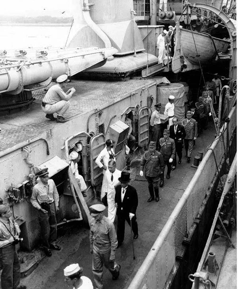 Japanese representatives follow their escort officer along the deck of USS Lansdowne (DD-486), after the surrender ceremonies.