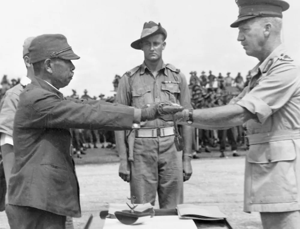 Hatazō Adachi, the commander of the Japanese 18th Army in New Guinea, surrenders his sword to the commander of the Australian 6th Division, Horace Robertson.