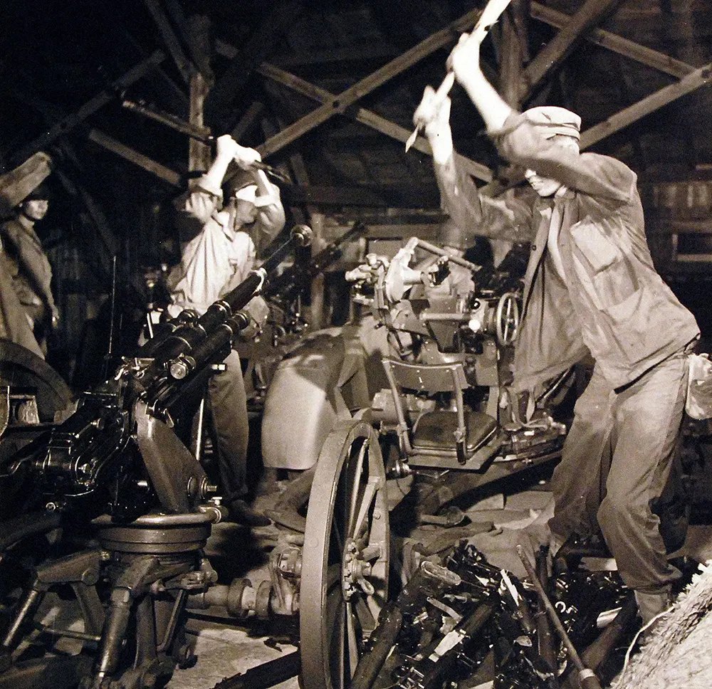 American soldiers destroy Japanese war equipment.