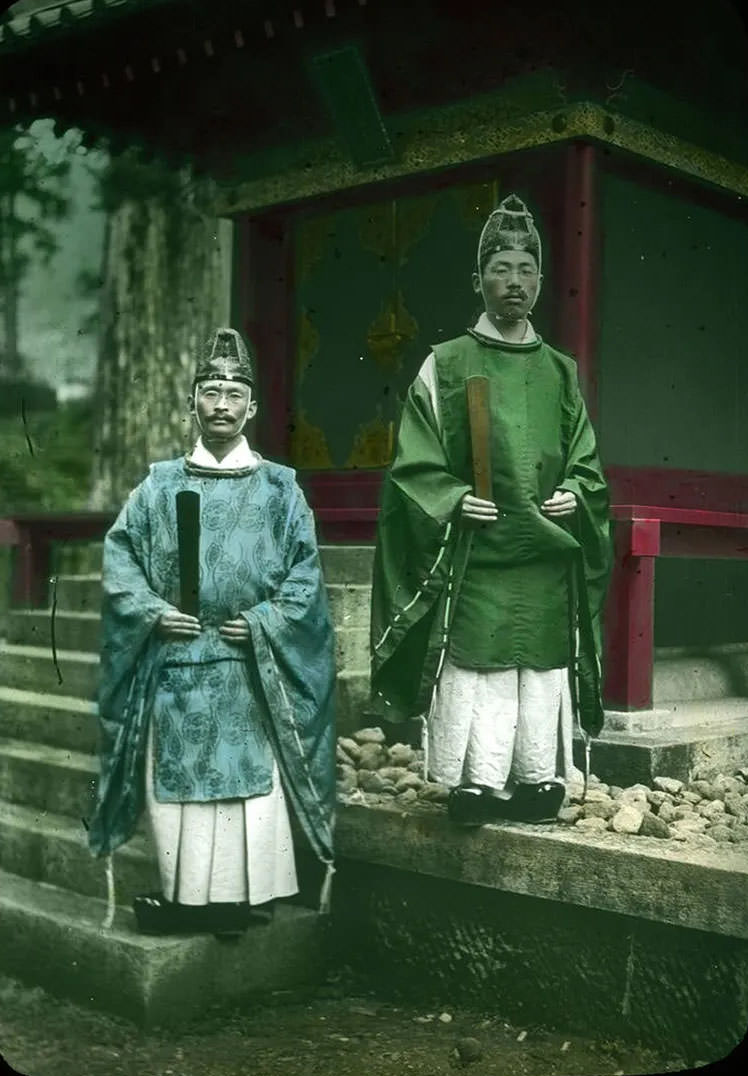 Two (priests ) outside shrine.