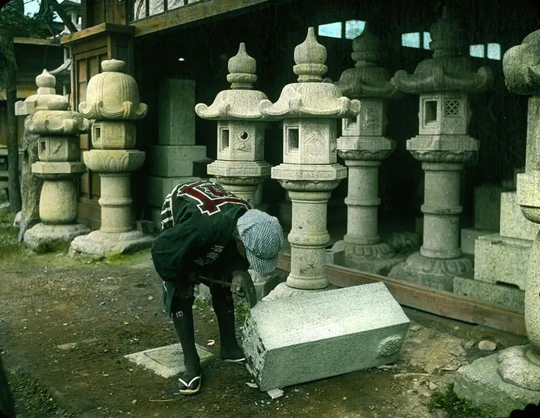 Man beginning to carve lantern from block of stone.