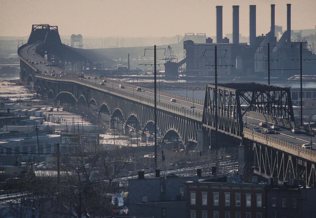 Pulaski Skyway with 1970s cars on a typically smoggy day. The Kearny Generation Station from 1925 was still in use and burning coal. Jersey City, Nov 1977