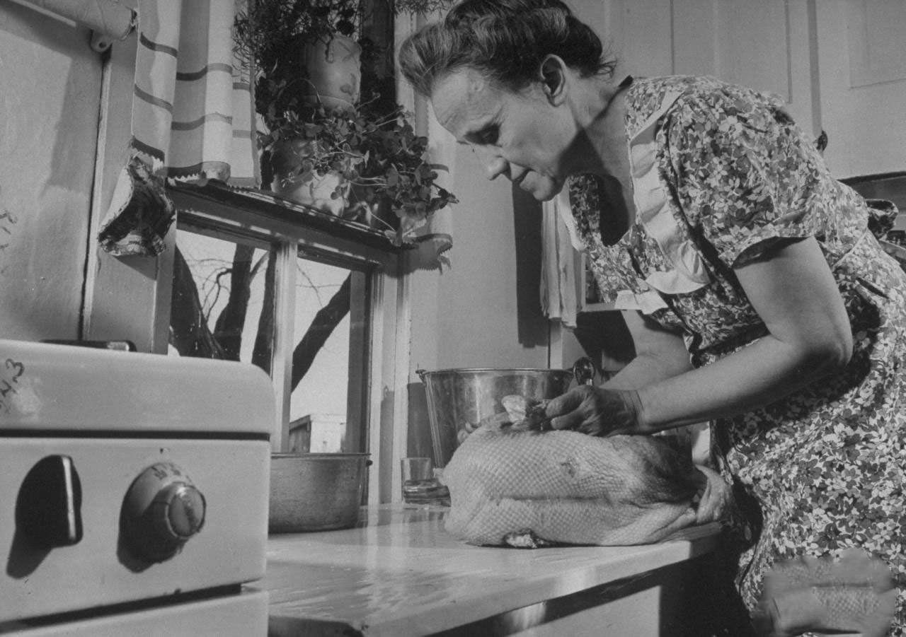 Mrs. James Ferdinand Irwin in kitchen preparing stuffed goose for Christmas dinner that marks the first family reunion in years w. her sons safely returned from WWII.