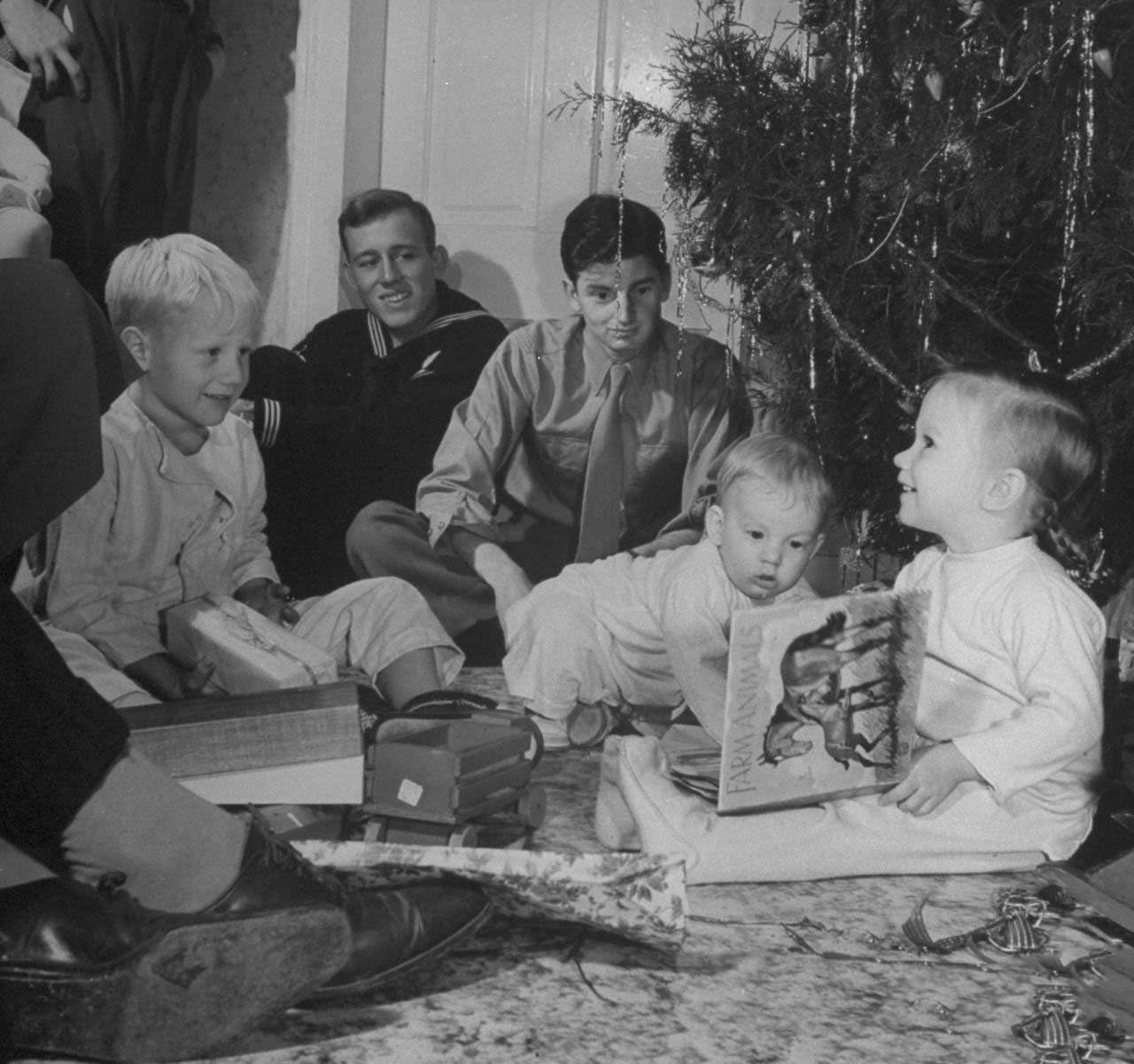 Grandchildren of James F. Irwin opening presents during an early Christmas party to celebrate safe return of sons and sons-in-law from WW II.