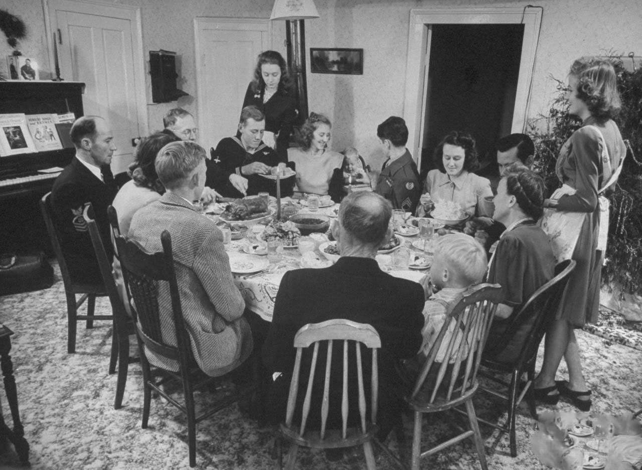 James Ferdinand Irwin family sitting around table having Christmas dinner, their young men safely returned from WWII, (clockwise from L) Fred Andrews, Mr. Irwin, Jim, unidentified, Jeanne, Joe, Levern Love, Myra Lee, Jack, unidentified, Mrs. Irwin Scotty