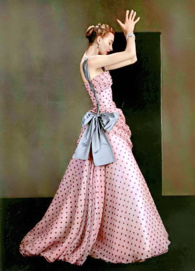 Marie-Thérèse is wearing pink organza dotted evening gown adorned with large grey satin bow by Grès, 1953