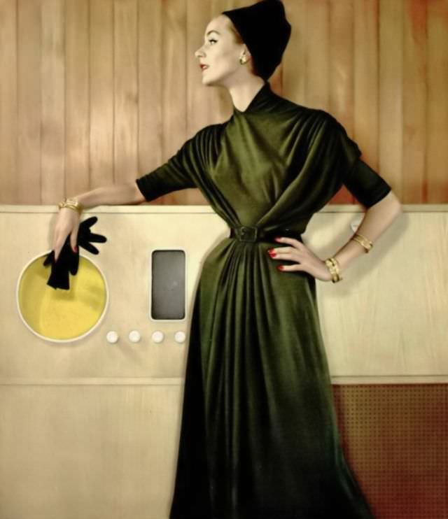Model in green wool jersey dress draped and gathered at the waist by Grès, 1957