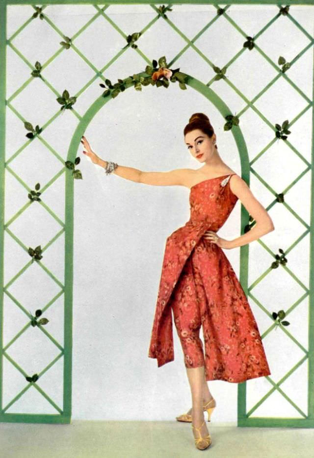 Model in print silk taffeta dress, one-shoulder bodice and over-skirt is split in two panels by Grès, 1957
