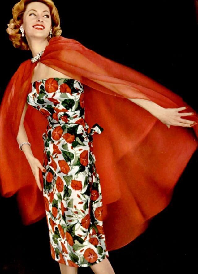 Ghislaine Arsac is wearing strapless silk floral print dress with vibrant red organdy cape by Grès, L'Officiel, 1958