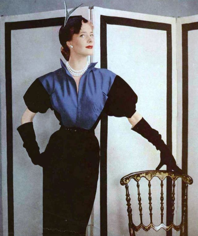 Model in black wool sheath dress, the bodice is of peacock blue faille, by Grès, 1951