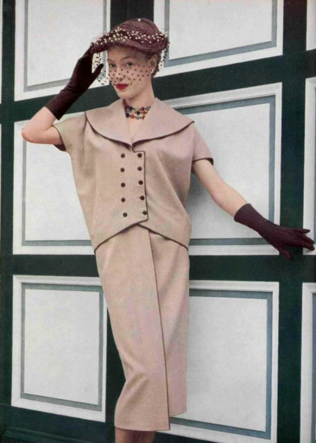 Anne Campion in dusty pink flannel two-piece by Grès, hat with voilette by Rose Valois, 1952