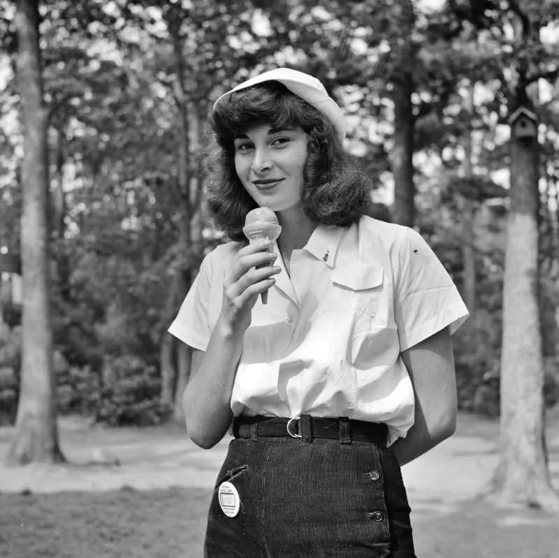 A student eating an ice cream cone at the National music camp in Interlochen, Michigan where 300 or more young musicians study symphonic music for 8 weeks each summer, August 1942.