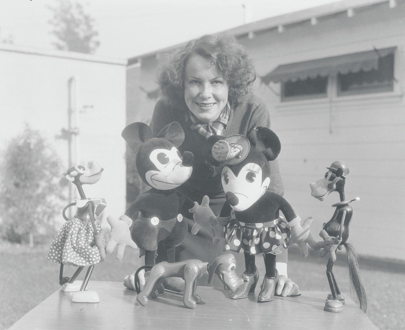 Woman Posing with Walt Disney Figurines. Doris Westcott of the Walt Disney Studios in Hollywood introduces Mickey Mouse, the most popular screen star in the industry, and his family.