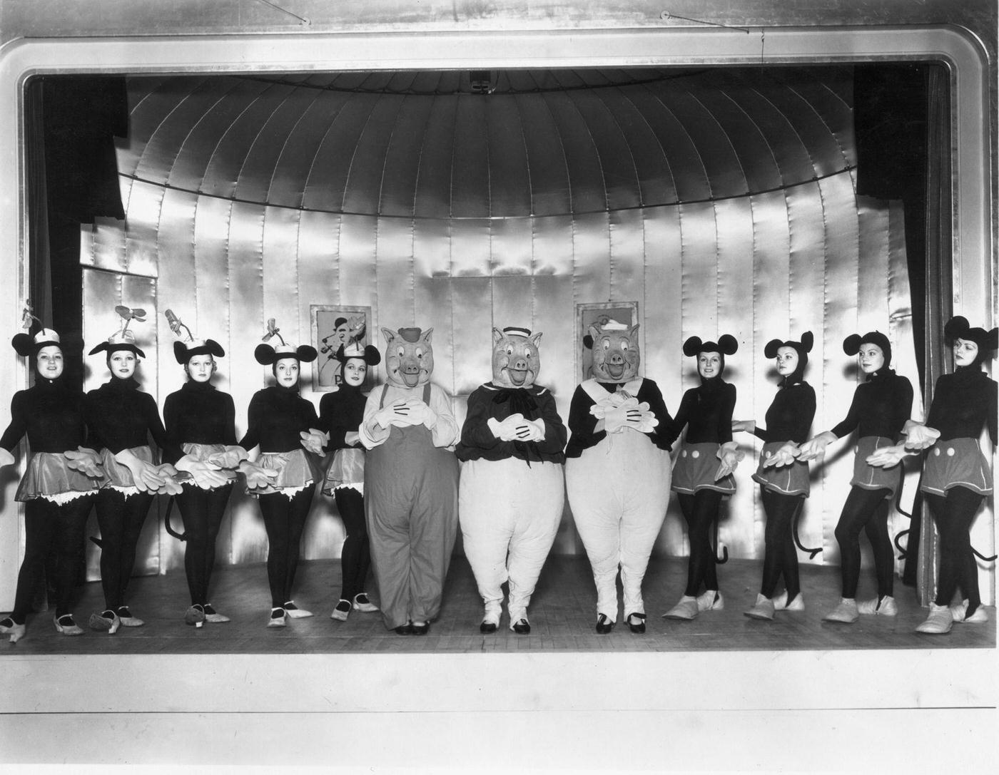A cast of young women as Mickey and Minnie Mouse, and the Three Little Pigs in a production of 'Monte Carlo Follies' at the Grosvenor House Hotel, London, 1934.