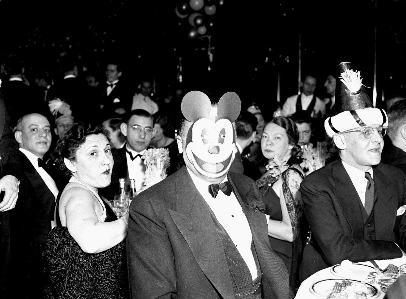 FBI director J. Edgar Hoover wearing Mickey Mouse mask at New Year's Eve party.