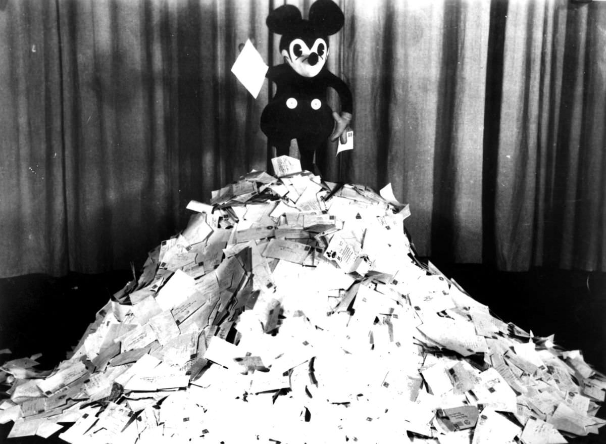 Mickey Mouse on top of a pile of letters he received from fans, 1928.