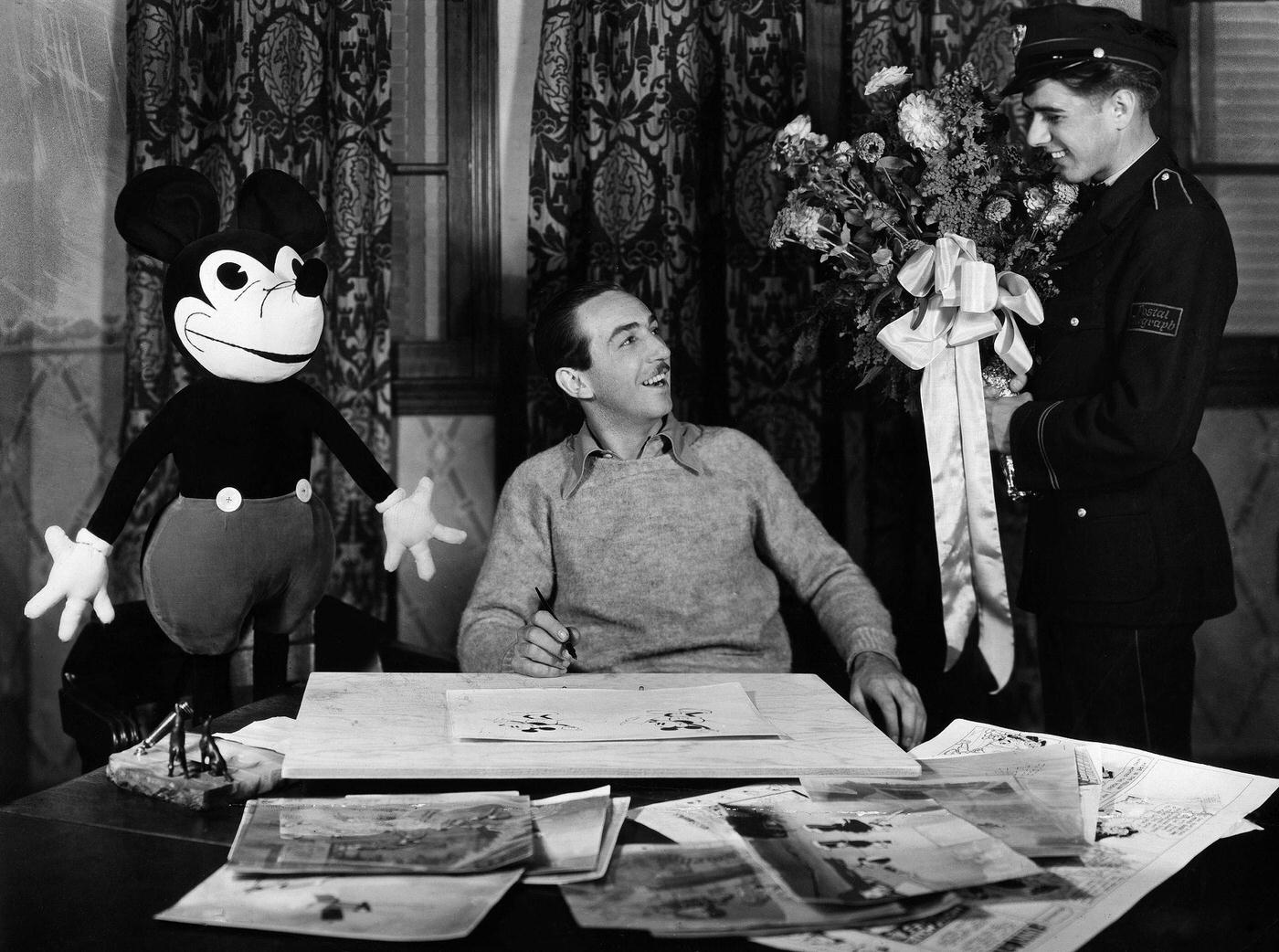 Walt Disney brings flowers to fifth birthday of Mickey Mouse, 1933